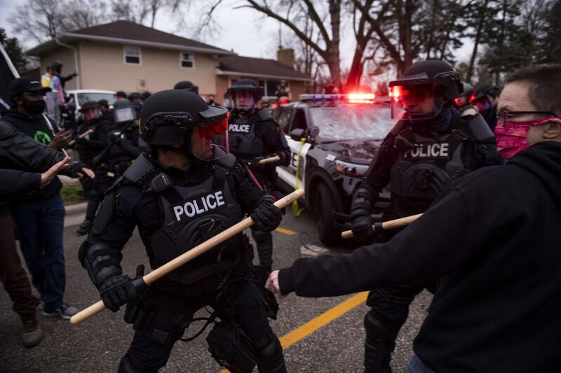 Protesters are pushed back by law enforcement officers in Brooklyn Centre, Minnesota, after a crowd gathered to protest against the death of Daunte Wright during a traffic stop earlier in the day. AFP