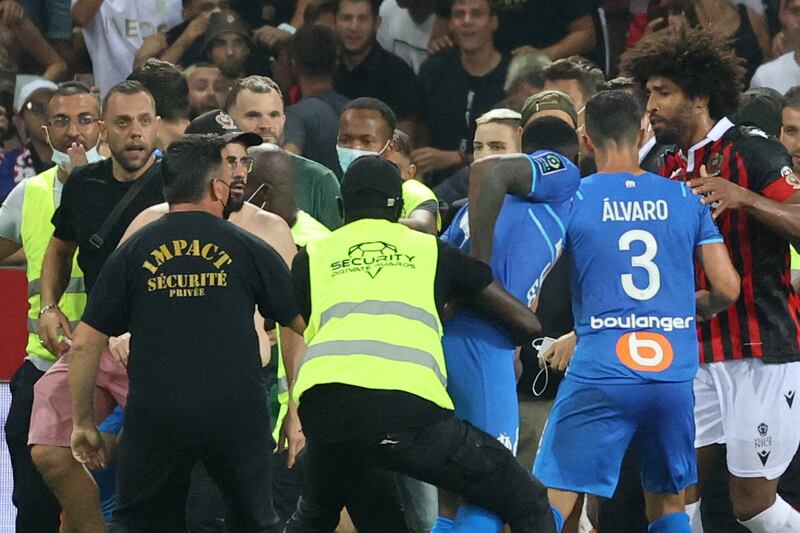 Fans try to invade the pitch. AFP