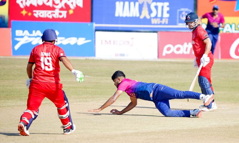 Ali Naseer of UAE dives to save a run. He played on with an injury to one of his fingers.