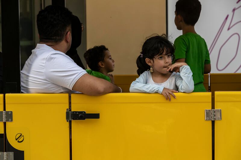A girl takes a ride on one of the many mini electric trains that ferry around visitors. Antonie Robertson / The National