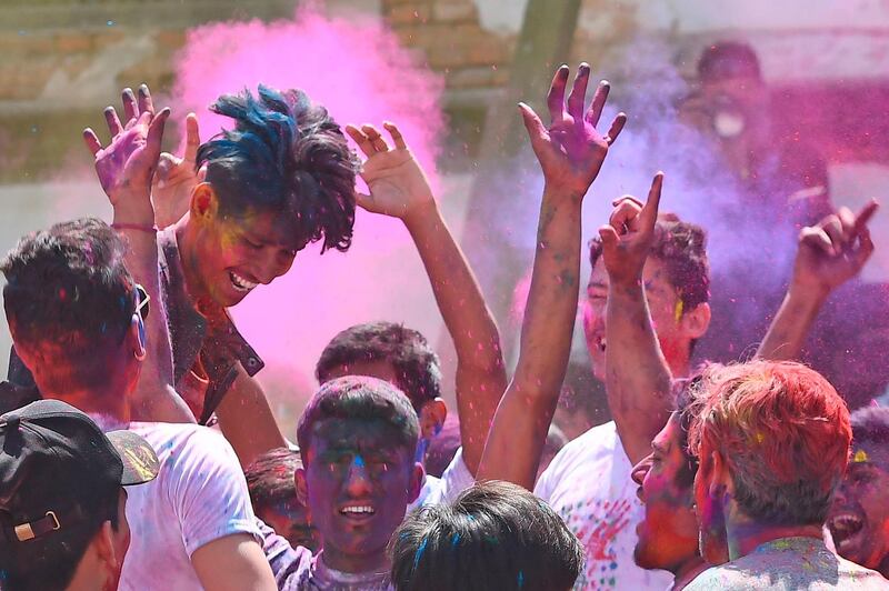 Revellers play with coloured powders as they celebrate Holi, the spring festival of colours, in Kathmandu on March 9, 2020. Holi is observed at the end of the winter season on the last full moon of the lunar month. AFP