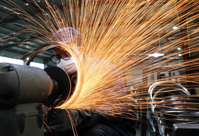 A worker wearing a face mask works on a production line manufacturing bicycle steel rim at a factory, as the country is hit by the novel coronavirus outbreak, in Hangzhou, Zhejiang province, China March 2, 2020. China Daily via REUTERS ATTENTION EDITORS - THIS IMAGE WAS PROVIDED BY A THIRD PARTY. CHINA OUT.