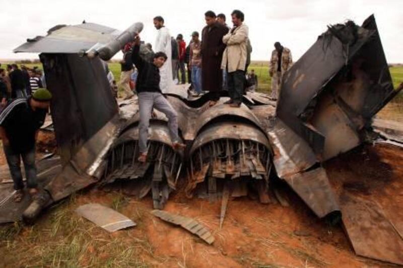 People look at a U.S Air Force F-15E fighter jet after it crashed near the eastern city of Benghazi March 22, 2011. The fighter jet crashed in Libya overnight after apparent mechanical failure but its crew were safe, a spokesman for the U.S. military Africa Command said on Tuesday. REUTERS/Suhaib Salem (LIBYA - Tags: CIVIL UNREST MILITARY POLITICS IMAGES OF THE DAY CONFLICT) *** Local Caption ***  SJS08R_LIBYA-_0322_11.JPG