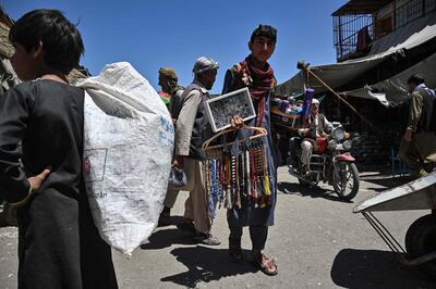 A youth selling prayer beads and jewelllery looks for customers at a market in Kabul. AFP