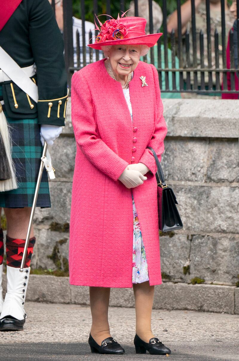 Queen Elizabeth II, wearing pink, during an inspection of the Balaklava Company, 5 Battalion The Royal Regiment of Scotland, at the gates at Balmoral, Scotland, on August 9, 2021. Getty Images