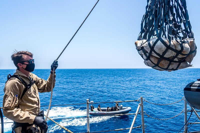 Petty Officer Second Class Jason Boisvenue, a Boatswain aboard HMCS CALGARY, reels in a cargo containing contraband onto the ship during a boarding operation to counter drug smuggling on 23 April, 2021 in the Arabian Sea during OPERATION ARTEMIS.

Please credit: Corporal Lynette Ai Dang, Her Majesty's Canadian Ship CALGARY, Imagery Technician
©2021 DND/MDN CANADA