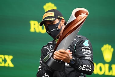 FILE PHOTO: Formula One F1 - Turkish Grand Prix - Istanbul Park, Istanbul, Turkey - November 15, 2020 Mercedes' Lewis Hamilton celebrates on the podium with a trophy after winning the race and the world championship Pool via REUTERS/Clive Mason/File Photo