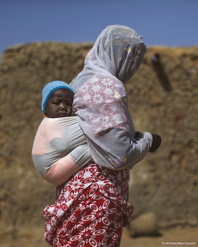 In Mali, a woman and her child displaced by violence in Timbuktu in 2015 walk through a village for internally displaced people in Mopti. Courtesy UN 