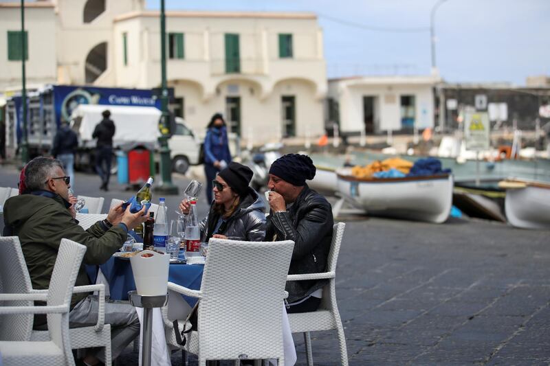 People sit at a restaurant in Marina Grande, the main port of the island of Capri, hoping for the return of foreign tourists and a busy summer season despite the coronavirus disease (COVID-19), on the glamorous tourist island of Capri, Italy, April 28, 2021. Picture taken April 28, 2021. REUTERS/Yara Nardi