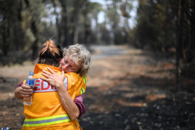This photo taken on January 8, 2020 shows 64-year-old orchardist Stephenie Bailey (R) reacting as she describes the impact bushfires have had on her farm in Batlow, in Australia's New South Wales state. Batlow has become one of the faces of the destruction wrought by the unprecedented disaster, which also hit areas usually untouched with Australia's summer fires, when shocking images of dead livestock along a road was shared by the national broadcaster ABC. - To go with AFP story Australia-fire-climate-environment, SCENE by Glenda KWEK
 / AFP / SAEED KHAN / To go with AFP story Australia-fire-climate-environment, SCENE by Glenda KWEK
