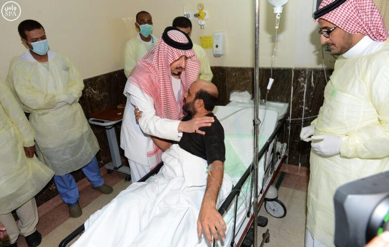 The governor of Asir, Prince Faisal bin Khaled bin Abdulaziz, comforts a man injured in a suicide bombing of a mosque inside a police compound in the city of Abha. Saudi Press Agency / AP