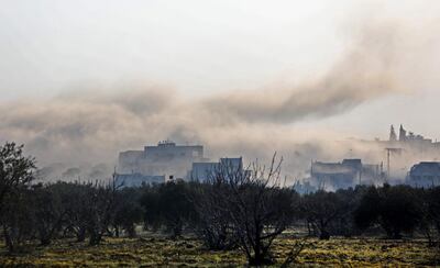 TOPSHOT - Smoke billows above buildings during an air strike by pro-regime forces on the village of Nayrab, about 14 kilometres southeast of the city of Idlib in northwestern Syria on February 25, 2020.  The Syrian regime advanced rapidly in the south of the opposition bastion of Idlib over the past weeks, but lost the town of Nayrab along the M4 highway to Turkish-backed rebels in the southeast late on February 24.  / AFP / Omar HAJ KADOUR
