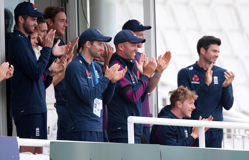 Dom Sibley, Stuart Broad, Mark Wood, Jonathan Trott, Dom Bess and James Anderson  applaud Jos Buttler and Zak Crawley off at the end of the day's play. Getty