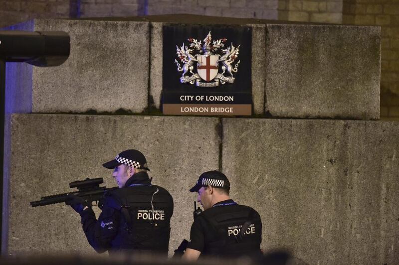 An armed Police officer looks through his weapon on London Bridge. Dominic Lipinski / PA via AP