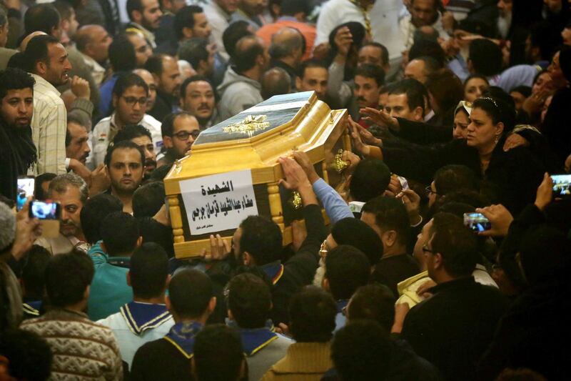 epa06409657 People mourn around a casket of a female victim during the funeral for victims of an attack, at a church in the working-class suburb of Helwan, Cairo, Egypt, 29 December 2017. According to a press release by Egypt's Foreign Press Office, at least eight were killed, including the gunman and a policeman and six civilians, when a gunman attempted to storm Mar Mina Church in Helwan district  EPA/AYMAN AREF