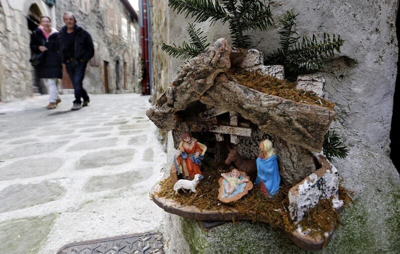 People pass by nativity scene during the 17th Nativity Scenes exhibition in the street of Luceram, southeastern France on December 20, 2014. This exhibition of Christmas cribs runs from December 1 to January 11. Sebastien Nogier / EPA