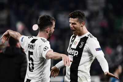 TOPSHOT - Juventus' Bosnian midfielder Miralem Pjanic (L) embraces Juventus' Portuguese forward Cristiano Ronaldo at the end of the UEFA Champions League round of 16 second-leg football match Juventus vs Atletico Madrid on March 12, 2019 at the Juventus stadium in Turin. / AFP / Marco BERTORELLO
