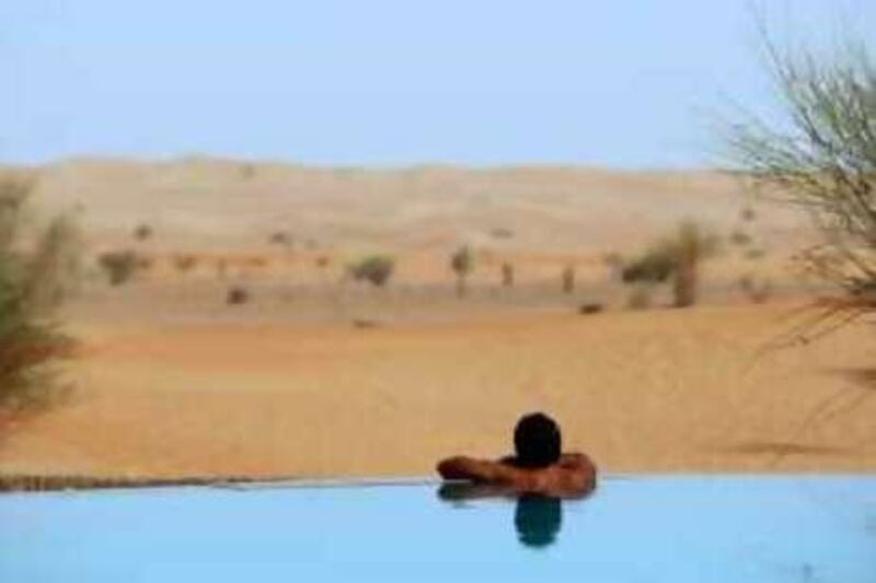 TO GO WITH AFP ARABIC STORY BY WISSAM KEYROUZ 
A foreigner enjoys the cool water in the middle of the desert at al-Maha resort and nature reserve, some 100 kms south of the Gulf emirate of Dubai, on June 30, 2008. Al-Maha is based on a blend of South Africa’s super-luxury lodges, the small exclusive island hideaways of Malaysia and Thailand and the legendary local Arab hospitality. The resort's original 27 square kilometre nature reserve was expanded to 225 square kilometres (five per cent of Dubai’s total land area). This is the largest protected land area under conservation management in the Gulf and the only one of its kind in the Middle East.       AFP PHOTO/MARWAN NAAMANI *** Local Caption ***  822425-01-08.jpg