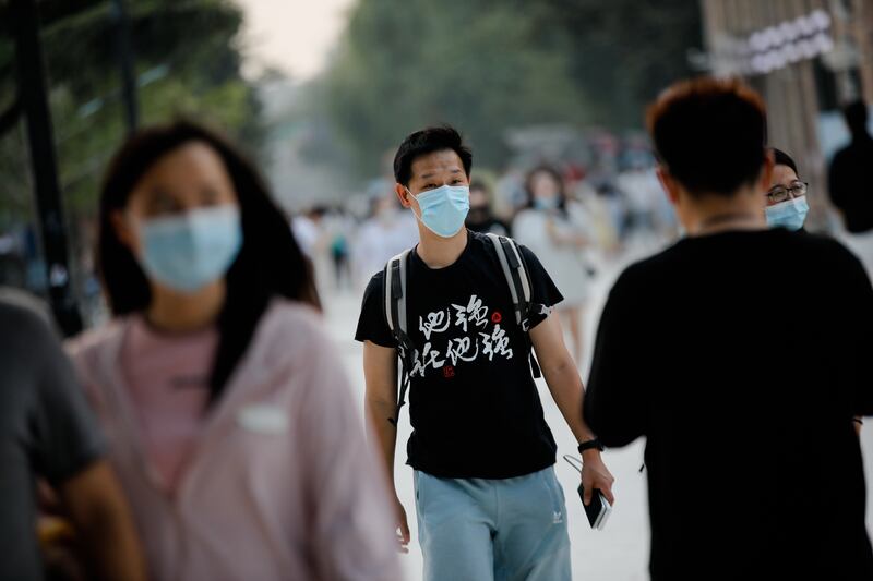 People wearing masks in Beijing this week. The report has said that misinformation, fuelled by social media, hampered basic public health measures, such as mask wearing and vaccines. EPA