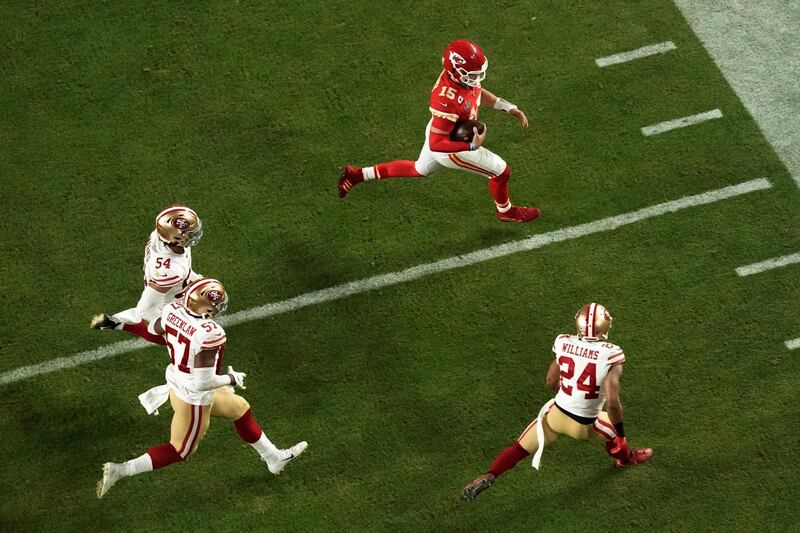 Kansas City Chiefs quarterback Patrick Mahomes is pursued by San Francisco 49ers' K'Waun Williams , Dre Greenlaw, and Fred Warn during the second half. AP