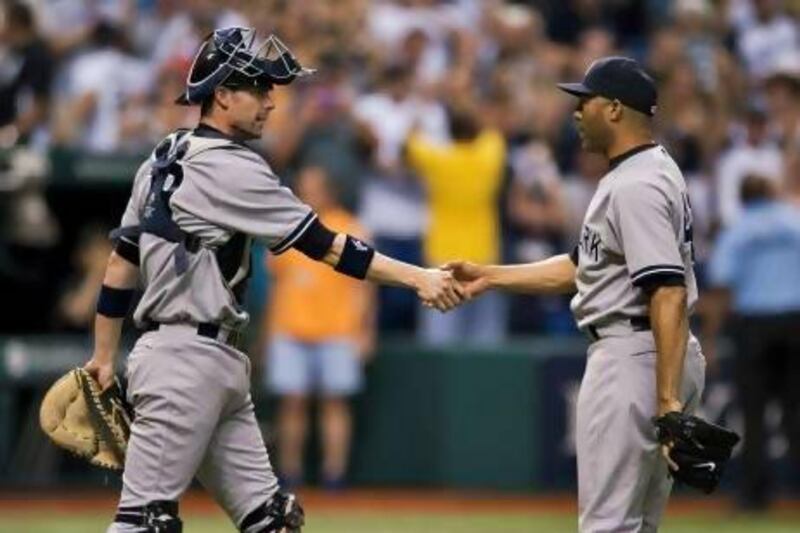 New York Yankees catcher Chris Stewart, left, congratulates closer Mariano Rivera after another successful save.