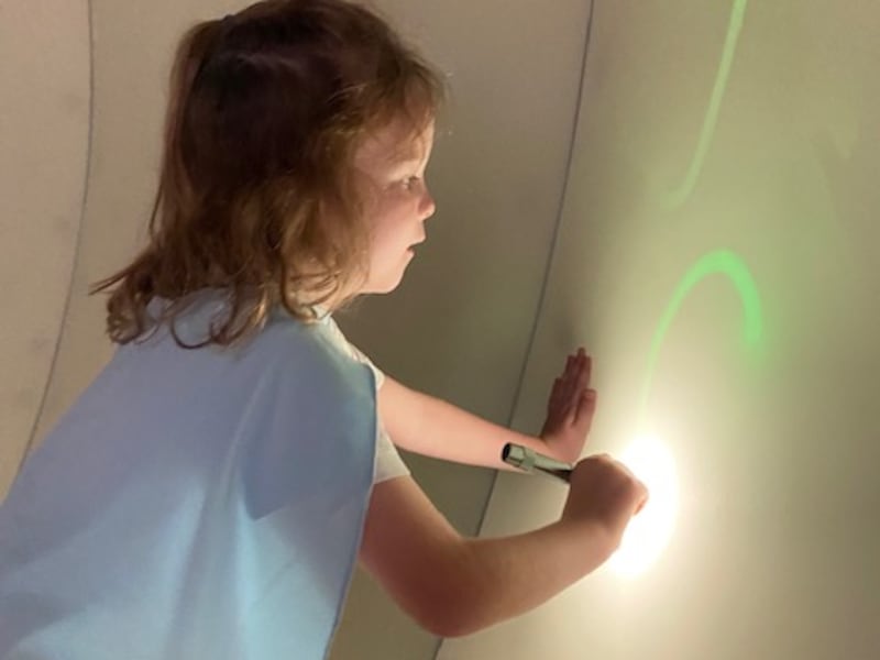 Fox, 6, creates drawings using light on the soft walls of the Design Lab.