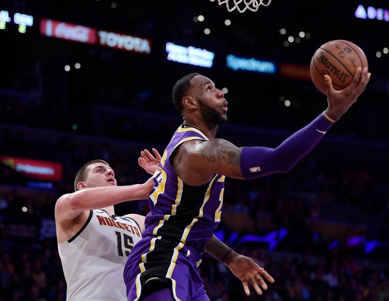 Los Angeles Lakers forward LeBron James, right, shoots as Denver Nuggets center Nikola Jokic defends during the second half of an NBA basketball game Wednesday, March 6, 2019, in Los Angeles. The Nuggets won 115-99. (AP Photo/Mark J. Terrill)