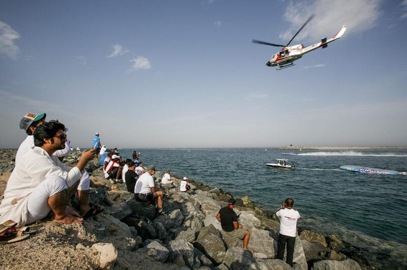 Spectators watch the capsized Austarlia Team boat as winners, Victory Team race by during the Fujairah Grand Prix. Mike Hewitt / Getty Images