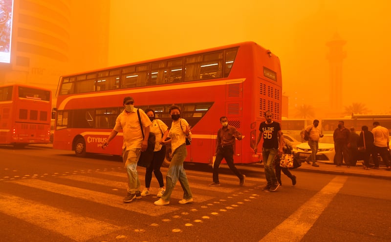 People walk on a street shrouded in heavy dust in Kuwait City. EPA