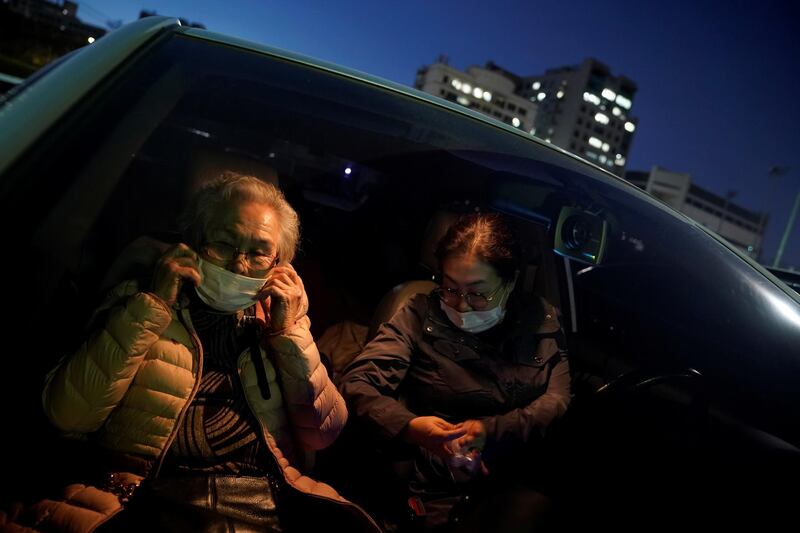 An elderly woman adjusts her mask as she waits for a movie to start at a drive-in theatre temporarily set up for residents following the outbreak of the coronavirus. Reuters