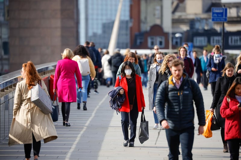 Commuters walk along London Bridge in London, U.K., on Thursday, May 6, 2021. The U.K.'s economic rebound from the pandemic is already fueling speculation that Bank of England policy makers this week will start discussing how and when they can ease their foot off the stimulus pedal. Photographer: Jason Alden/Bloomberg