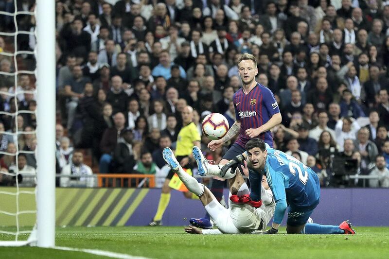 MADRID, SPAIN - MARCH 02: Ivan Rakitic of Barcelona scores his sides first goal past Thibaut Courtois and Sergio Ramos of Real Madrid during the La Liga match between Real Madrid CF and FC Barcelona at Estadio Santiago Bernabeu on March 02, 2019 in Madrid, Spain. (Photo by Gonzalo Arroyo Moreno/Getty Images)