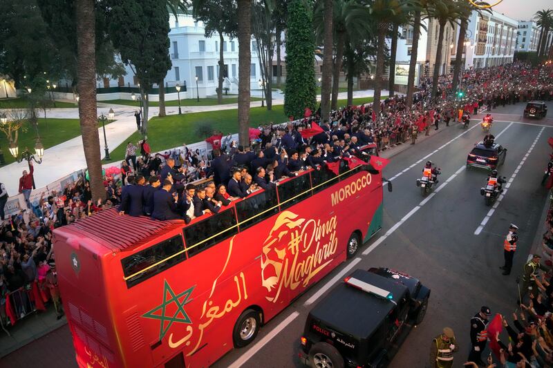 The Morocco players wave to fans from their team bus as they parade through central Rabat. AP 
