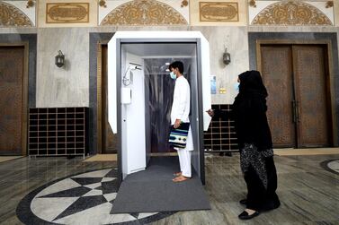 A man wearing a face mask passes through a sanitisation system that has been installed at Al Farooq Omar Bin Al Khattab Mosque in Dubai. Getty Images