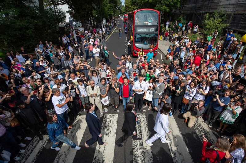 Thousands of fans gather to walk across the Abbey Road zebra crossing, on the 50th anniversary of British pop musicians The Beatles doing it for the cover of their album 'Abbey Road' in St Johns Wood in London.  AP