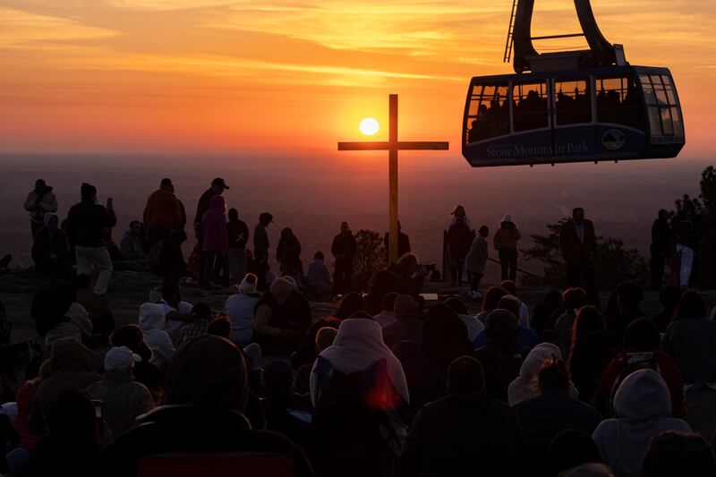 The sun rises behind a cross as hundreds attend the Easter sunrise service on top of Stone Mountain in Stone Mountain, Georgia, US. AP