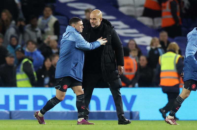 Manchester City's Phil Foden manager Pep Guardiola share an embrace at the final whistle. AFP