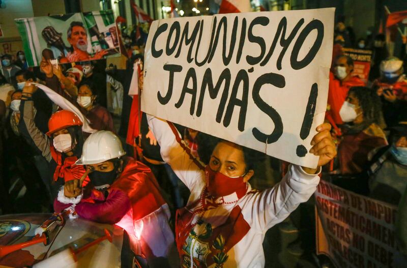 A protester holds a banner that reads "Communism Never!" as radical right-wing activists attempt to march to the Government Palace in Lima.
