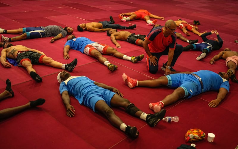 Members of the Cuban national Greco-Roman wrestling team stretch during training in Varadero, Cuba. AP