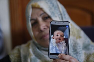 The grandmother of nPalestinian baby Omar Yagi displays a picture of him in Gaza City on June 22, 2020. AFP