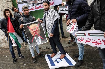 Palestinian protesters prepare to burn a picture of US President Donald Trump in the southern Gaza Strip town of Rafah on December 6, 2017. 
President Donald Trump is set to recognise Jerusalem as Israel's capital, upending decades of careful US policy and ignoring dire warnings from Arab and Western allies alike of a historic misstep that could trigger a surge of violence in the Middle East. / AFP PHOTO / SAID KHATIB