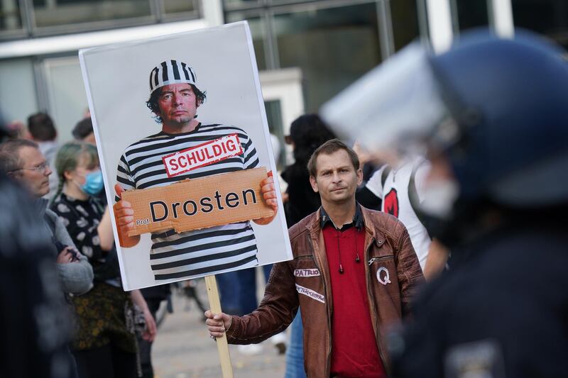 Protesters display a poster of German virologist Christian Drosten with the word "guilty". Getty Images