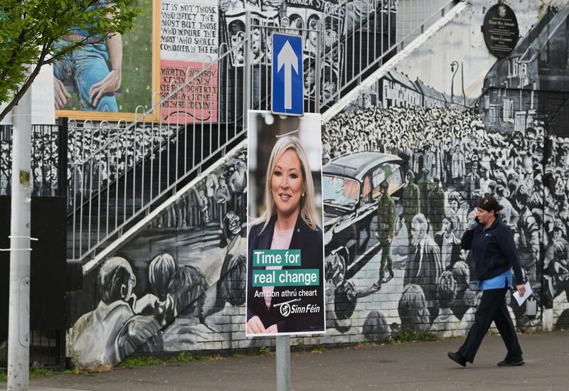 A poster of Sinn Fein's Michelle O'Neill against the backdrop of a republican mural in west Belfast. Getty