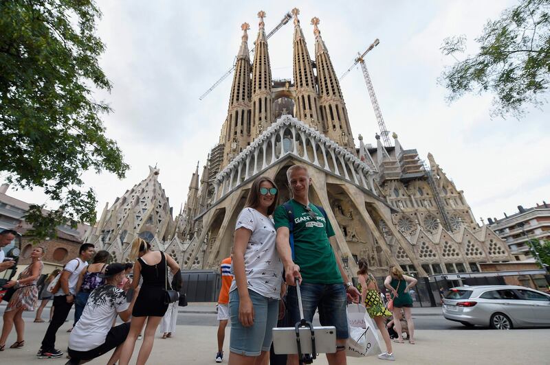 Tourists pose for selfies in front of the "Sagrada Familia" (Holy Family) basilica in Barcelona on August 19, 2017, two days after a van ploughed into the crowd, killing 13 persons and injuring over 100.
Drivers have ploughed on August 17, 2017 into pedestrians in two quick-succession, separate attacks in Barcelona and another popular Spanish seaside city, leaving 14 people dead and injuring more than 100 others. / AFP PHOTO / LLUIS GENE