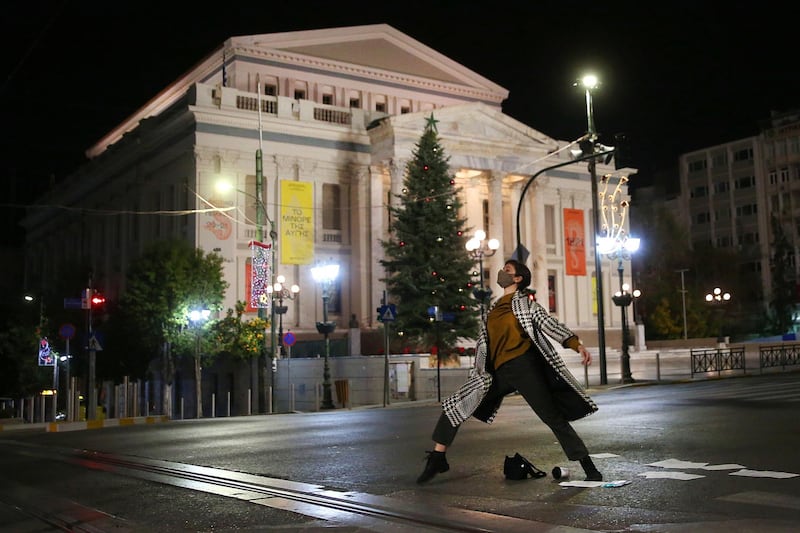 Dancer Antonia Exertzi performs choreography by Patricia Apergi, wearing a protective face mask, at a deserted Iroon Polytechniou Avenue, outside the Piraeus Municipal Theatre, in Piraeus, Greece, on December 4, 2020. EPA