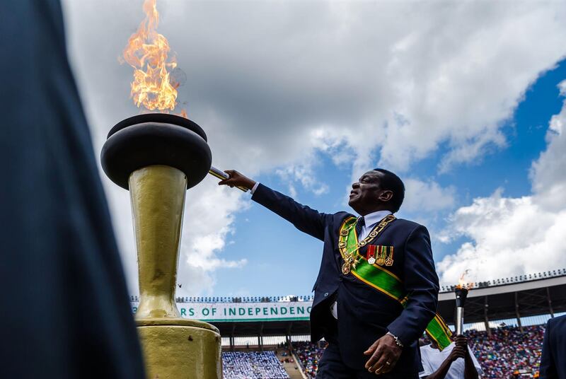 Zimbabwe's President Emmerson Mnangagwa lights the Eternal Flame of Freedom during Zimbabwe Independence Day celebrations at the National Sports Stadium in Harare. Jekesai Njikizana / AFP Photo