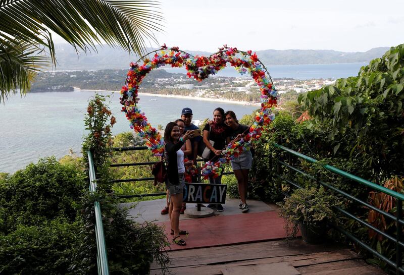 Resort workers who were cut-off from their jobs take a 'selfie' in Mount Luho viewpoint in the holiday island of Boracay, on April 26, 2018. Erik De Castro / Reuters