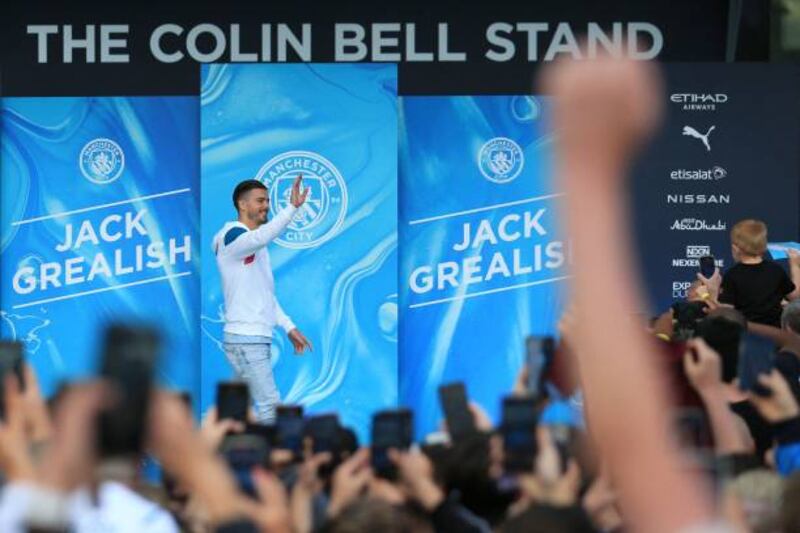 Jack Grealish waves to Manchester City fans outside the Etihad Stadium.