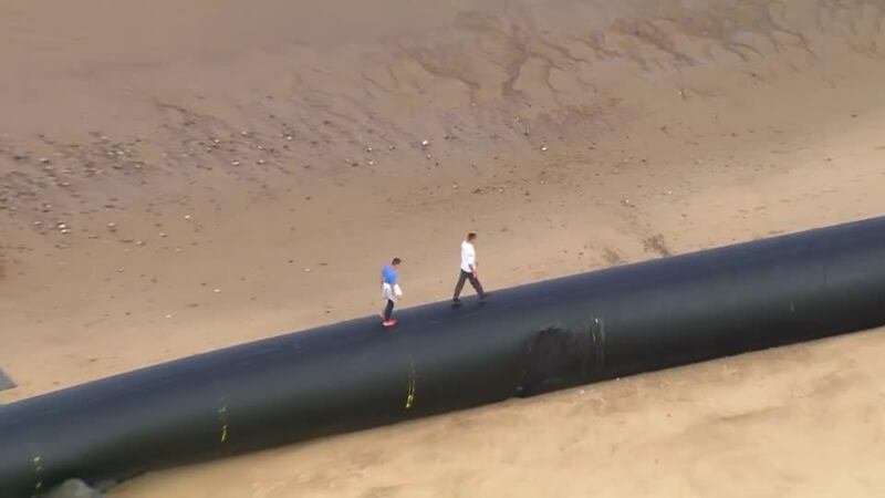 Large Norwegian-made bore pipes on their way to Algeria are found wash up on England's Norfolk coast. No reporter narration.