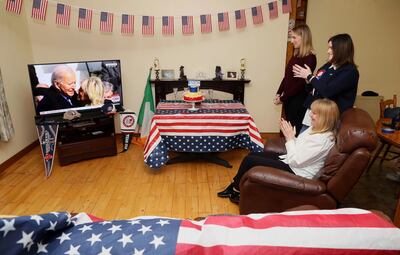Veronica McKevitt, seated, a distant cousin of President-elect Joe Biden, and her daughters Andrea McKevitt, background right and Ciara, applaud at their home as they watch the inauguration of Joe Biden as the 46th President of the United States, in Louth, Ireland, Wednesday, Jan. 20, 2021. (Brian Lawless/PA via AP)